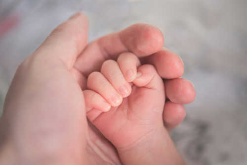 Baby hand in adult hand